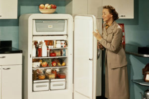 mulher abrindo geladeira antiga