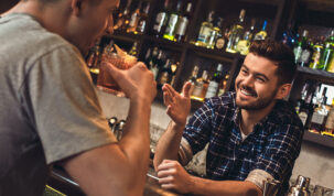 bartender praticando noções básicas de hospitalidade atrás do balcão