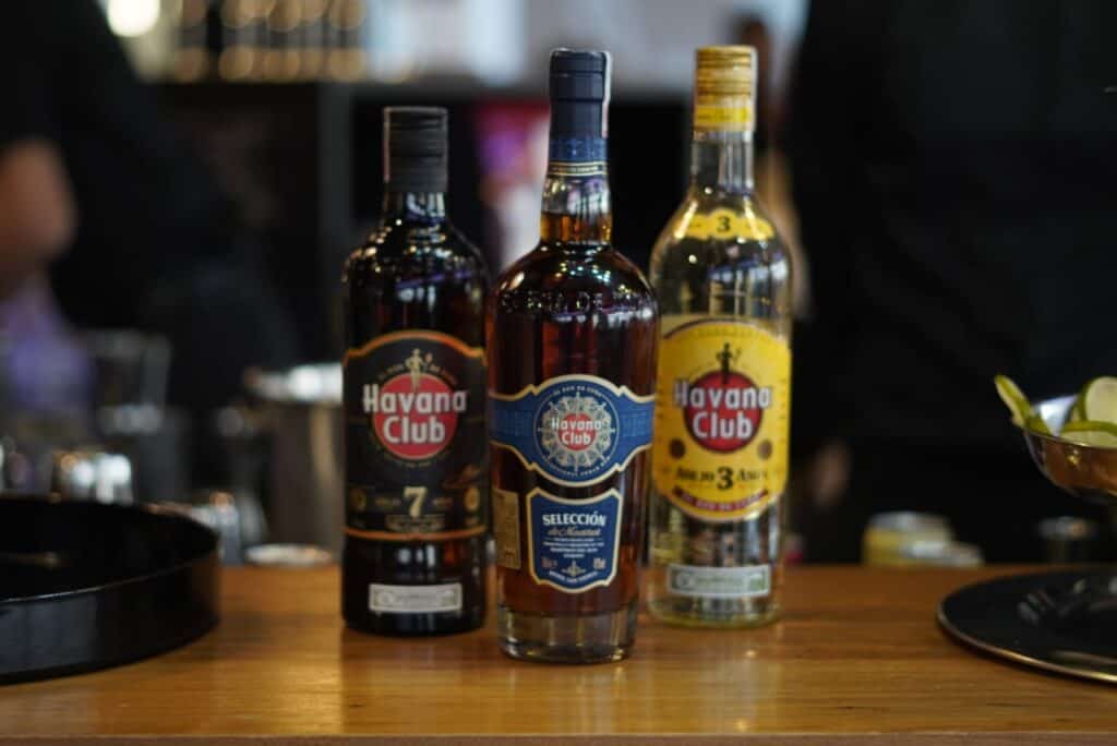 três garrafas de rum havana club posicionadas sobre balcão de bar
